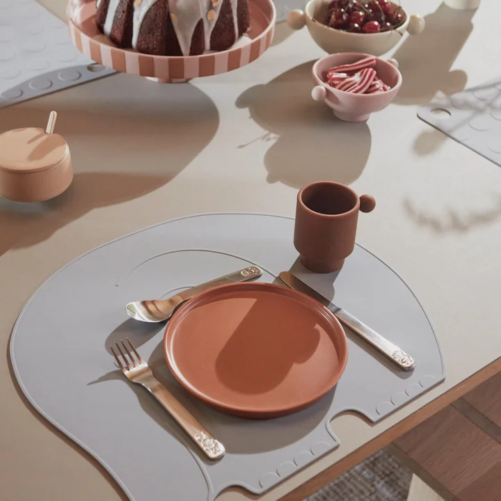 The We Love Animals children's cutlery, the Tiny Inka silicone mug, the Tiny Inka silicone bowl and the Toppu tray from OYOY on the dining table