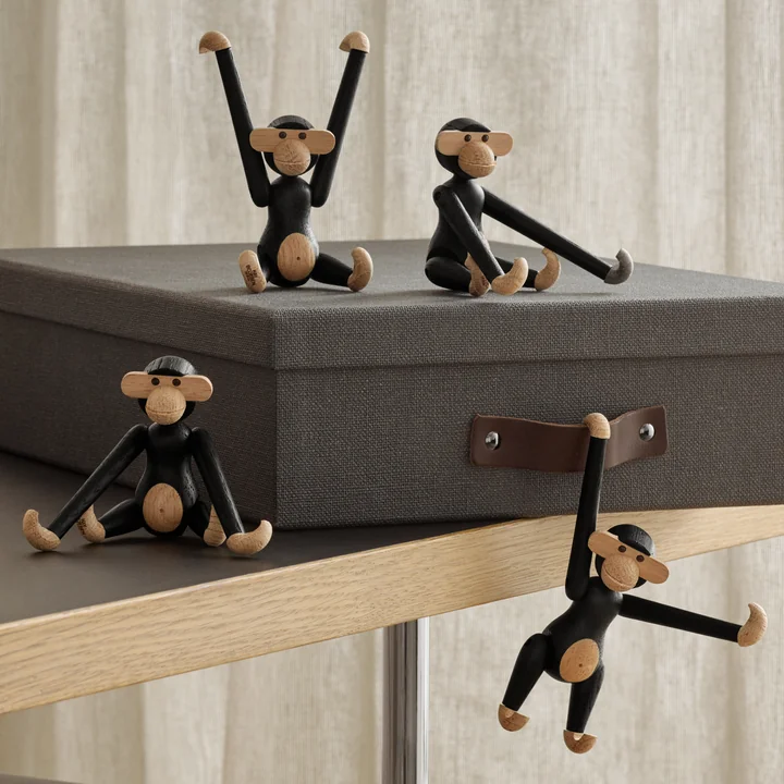 The wooden monkey mini, stained black oak by Kay Bojesen on and on a storage box