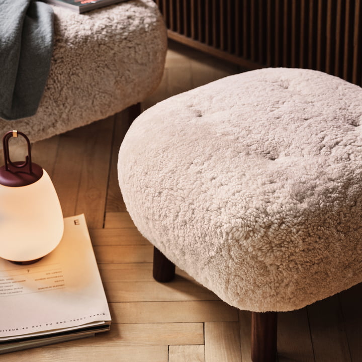 The Pouf ATD1 from & tradition on a light wooden floor next to another pouf