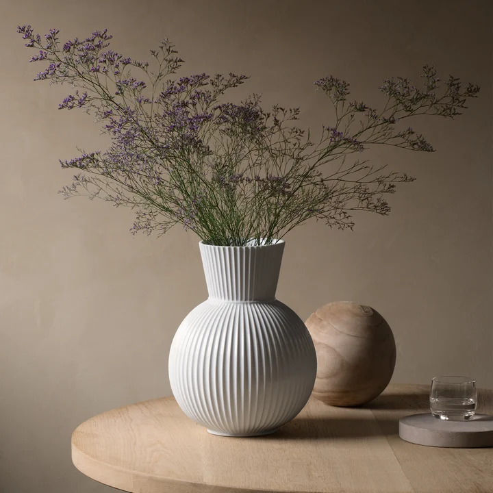The Lyngby Tura vase, H 34 cm, white from Lyngby Porcelæn among other decorative objects on a side table