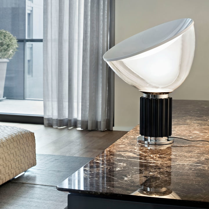 The Taccia small LED table lamp from Flos on a marble table in the living area