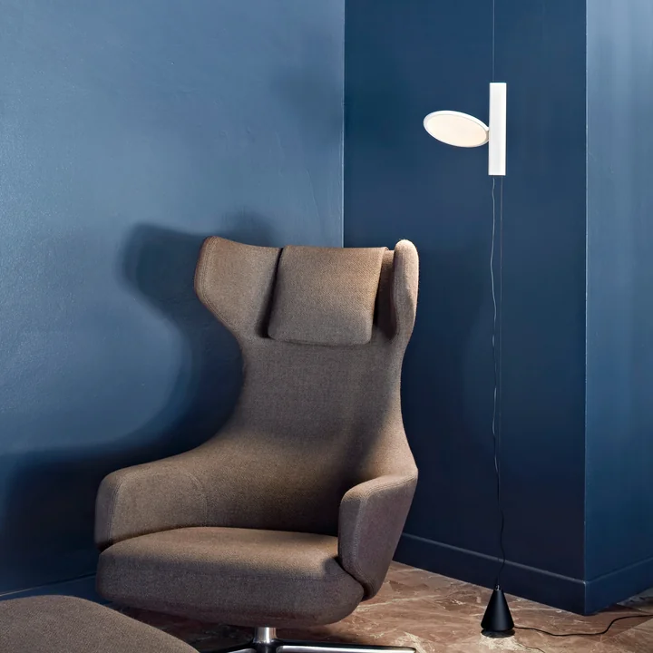 The OK luminaire, white from Flos next to a reading chair