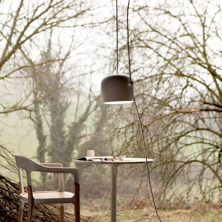 The AIM LED pendant lamp from Flos outdoors above a small table