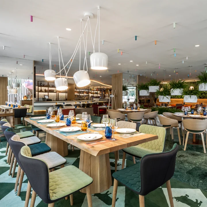 The AIM LED pendant luminaire from Flos above the tables in a restaurant.
