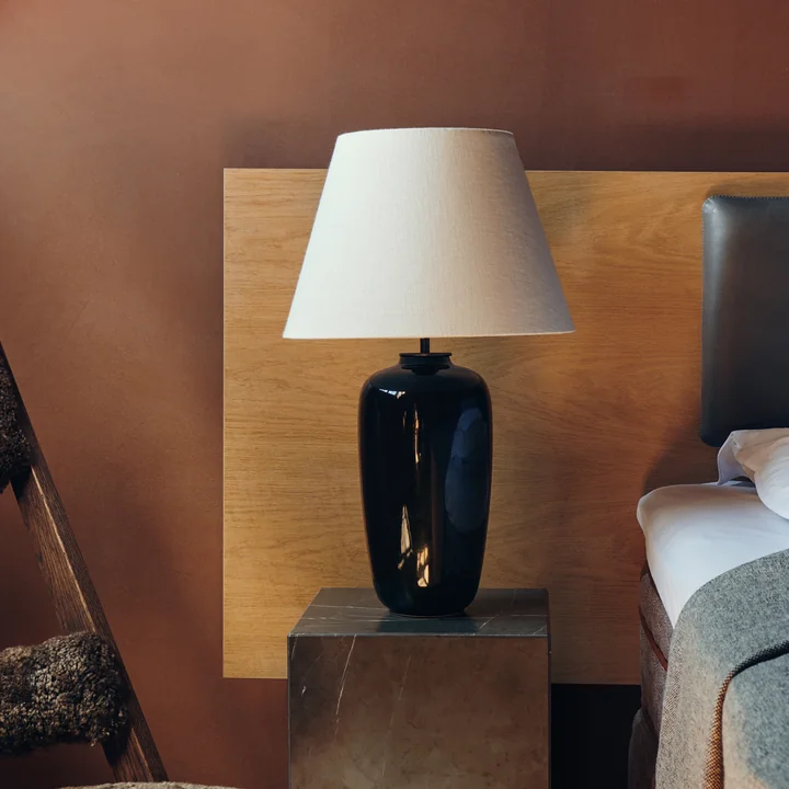 The Torso table lamp, black / off white from Audo on the bedside table next to the bed