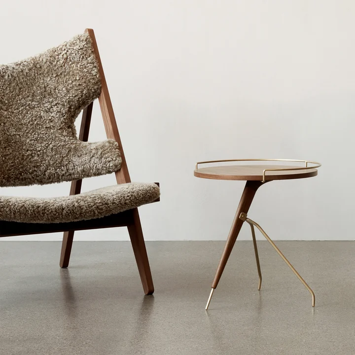 The Umanoff side table Ø 43 / 40 x H 45 cm, walnut / brass next to the Knitting Chair Walnut Sheepskin Cork 19 by Audo