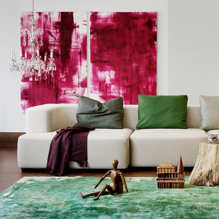 The modular Alphabet sofa from in Fritz Hansen front of a green carpet and in combination with abstract works of art