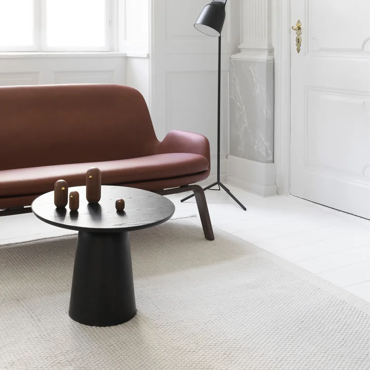 The Turn coffee table from Normann Copenhagen in front of a leather sofa in a bright living area