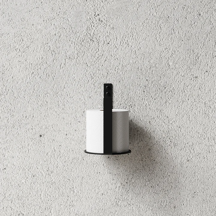 The toilet roll holder Extra from Nichba Design on a stone wall