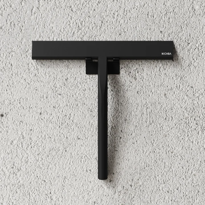 The shower squeegee from Nichba Design on a stone wall