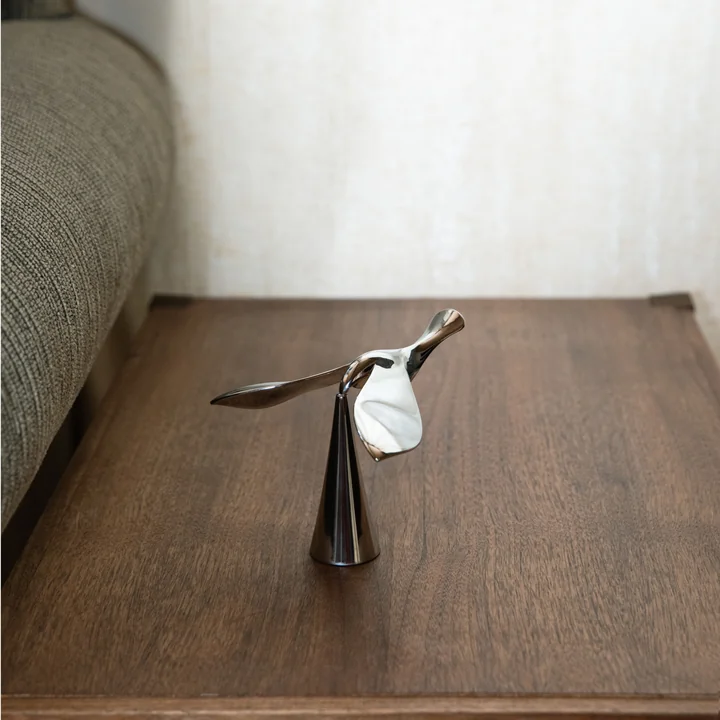 The Tipsy bottle opener from Umbra on a dark wooden surface