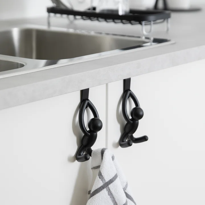 The Buddy door hooks from Umbra on the kitchen cabinet under the sink