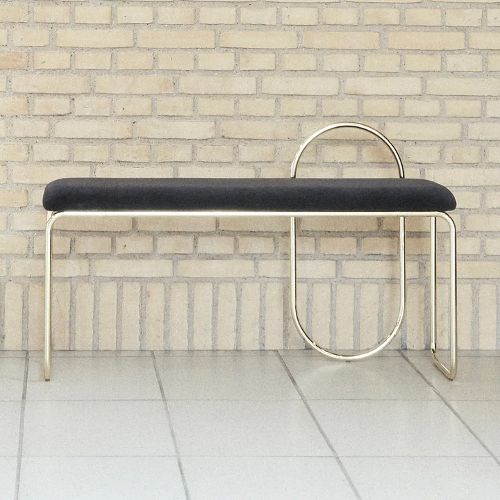 The Angui bench from AYTM in front of a stone wall