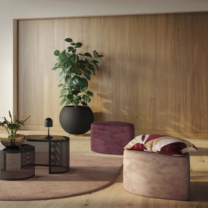 The Globe flowerpot from AYTM with a high houseplant next to the Stilla Poufs from AYTM