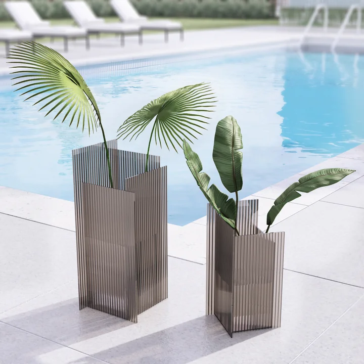 The Flos vase of AYTM in its various sizes outdoors by a pool