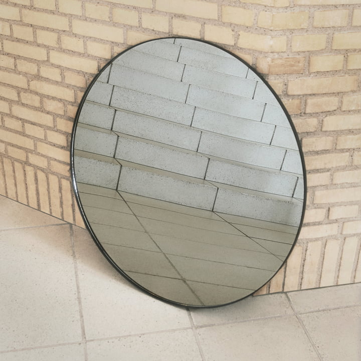 The Circum wall mirror from AYTM leaning against a wall