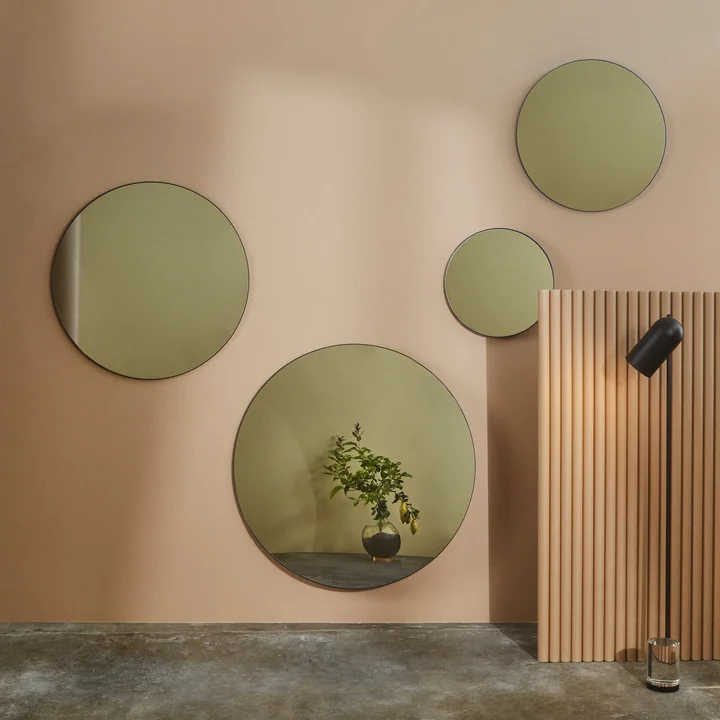Different size Circum wall mirror from AYTM on a salmon colored wall
