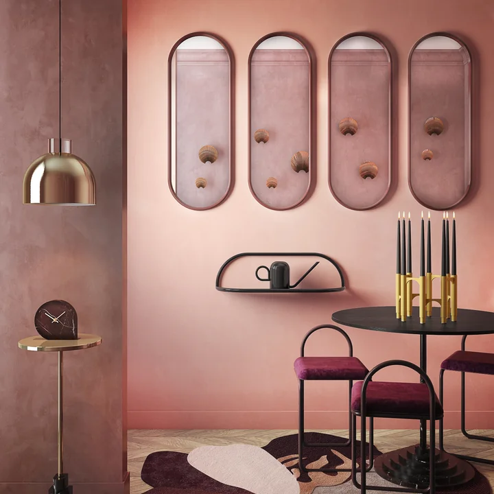 Several Angui wall mirrors from AYTM on a pink wall above the dining table