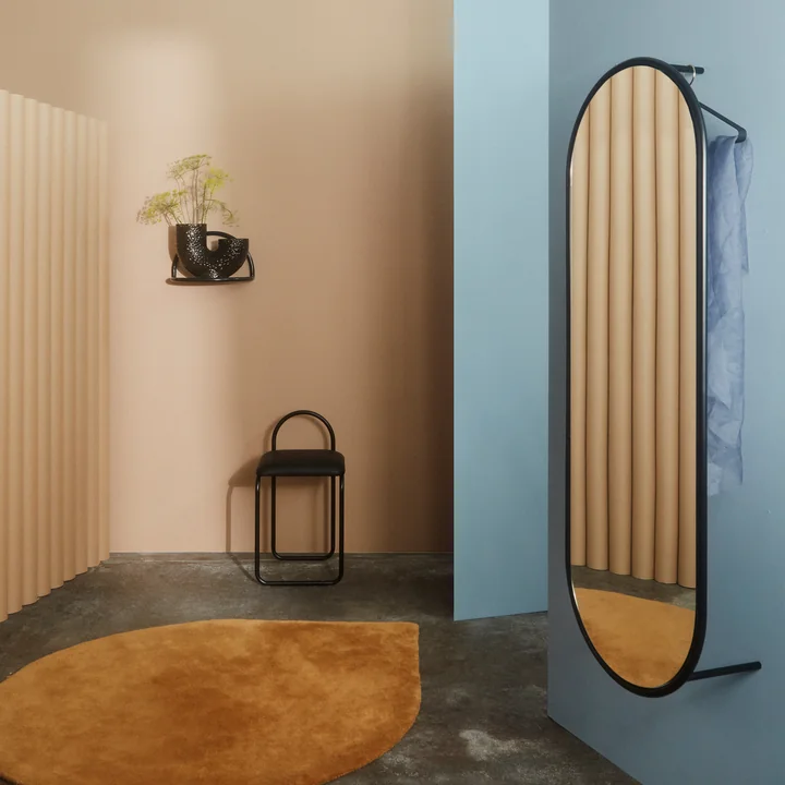 The Angui wall mirror from AYTM on a blue wall in the dressing room