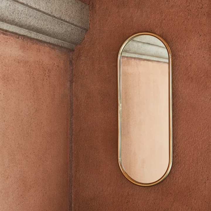 The Angui wall mirror from AYTM on a stone wall