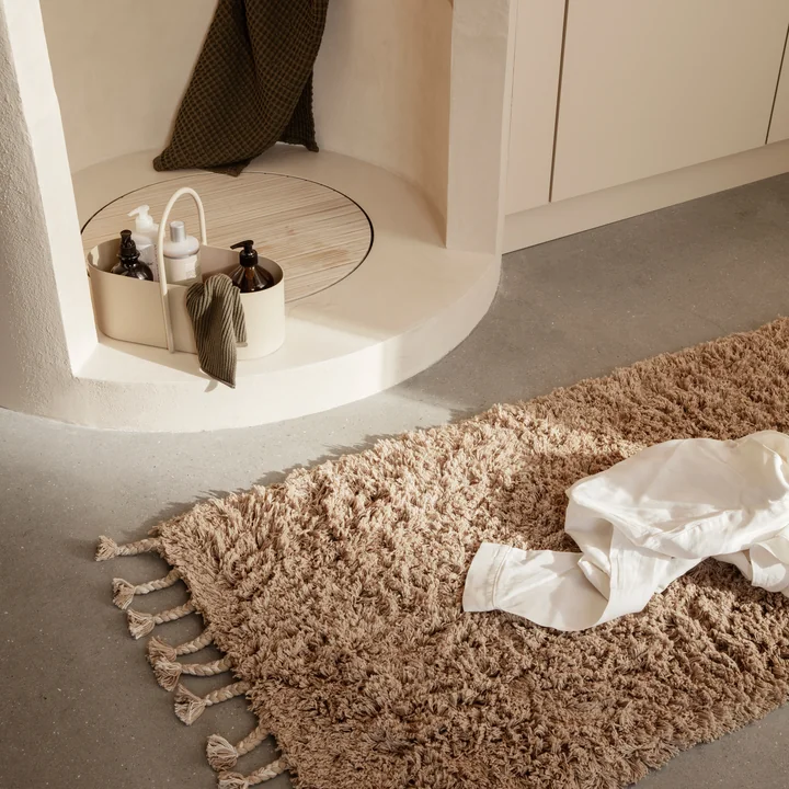 The Amass high-pile runner from Ferm Living next to the stone shower in the bathroom
