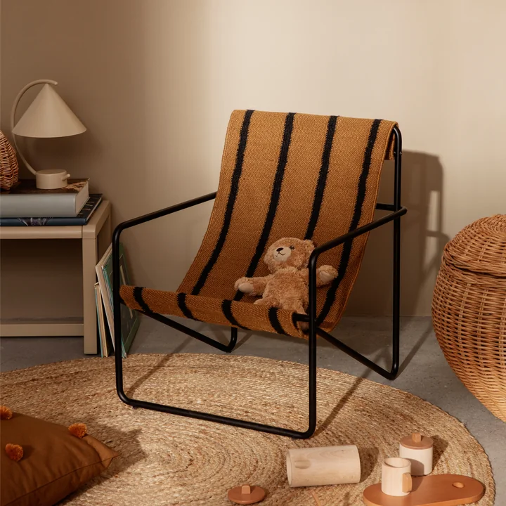 The Desert Chair Kids by Ferm Living on a jute carpet with cuddly animals and toys
