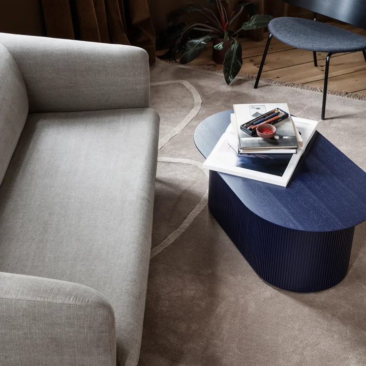 The Turn sofa (3-seater) from Ferm Living in linen natural in front of a blue wooden side table
