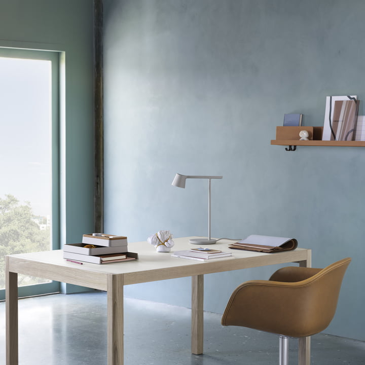 The Tip Table lamp from Muuto on a bright desk with a leather office chair