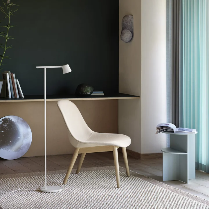 The Tip floor lamp from Muuto next to a bright chair in the cosy living area