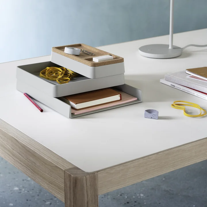 The Arrange Desktop Organizer from Muuto on a white desk next to a lamp