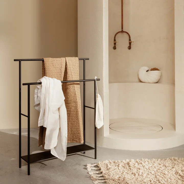 The Dora towel rail from Ferm Living with towels next to the stone shower