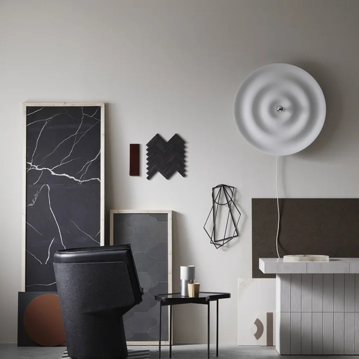 The Alma Wall and ceiling lamp from Wästberg in a room full of geometric art objects in black and grey