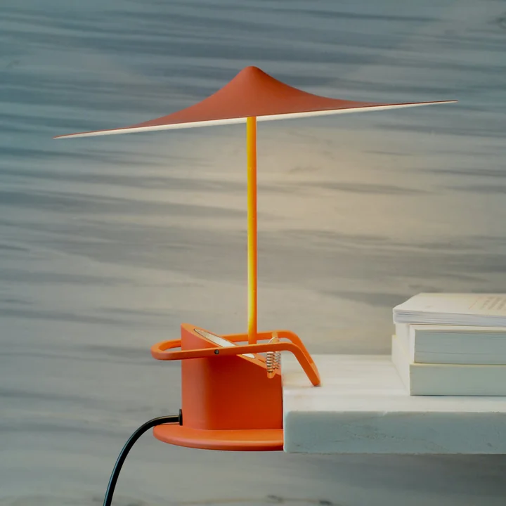 The w153 île table lamp from Wästberg in poppy red on a stone shelf
