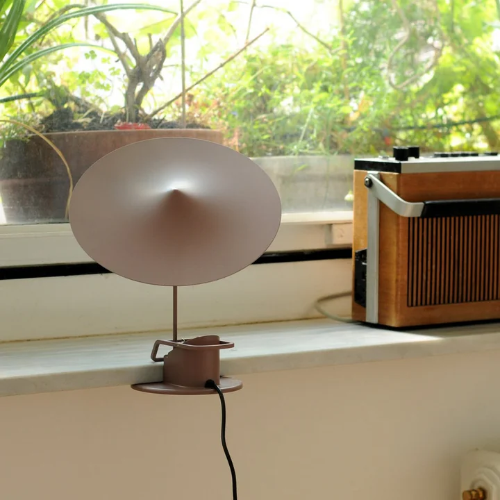 The w153 île table lamp from Wästberg clamped to a windowsill next to a radio