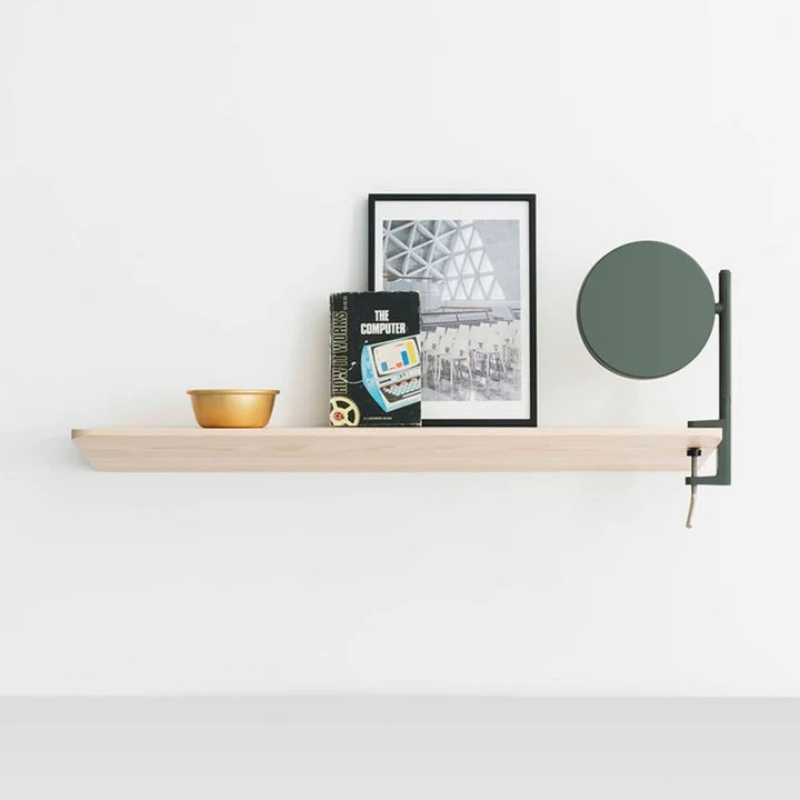 The w182 Pastille LED clamp light from Wästberg on a bright wooden shelf with books and pictures