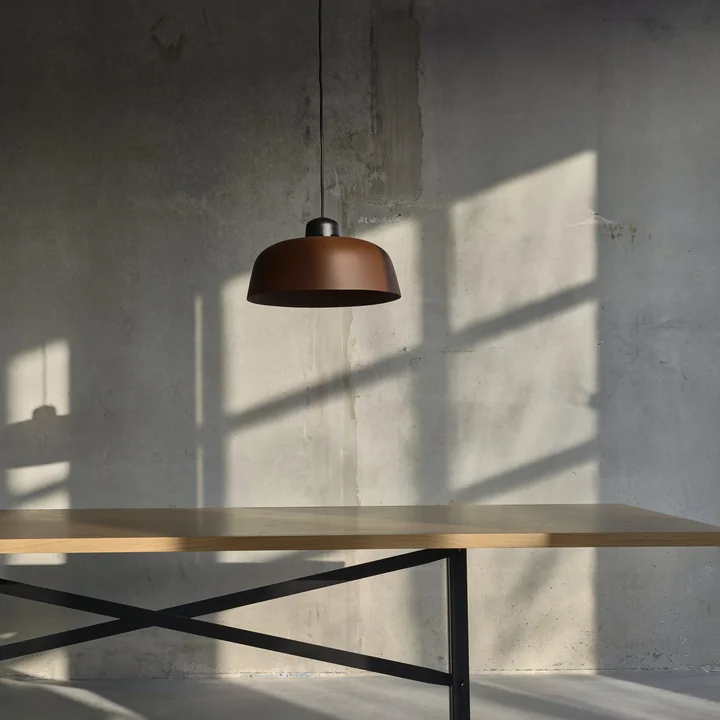 The w162 Dalston LED pendant luminaire from Wästberg above a wooden table with metal frame