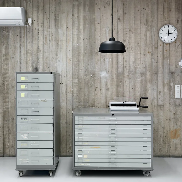 The w162 Dalston LED pendant luminaire from Wästberg in a simple office corridor with grey mobile shelves