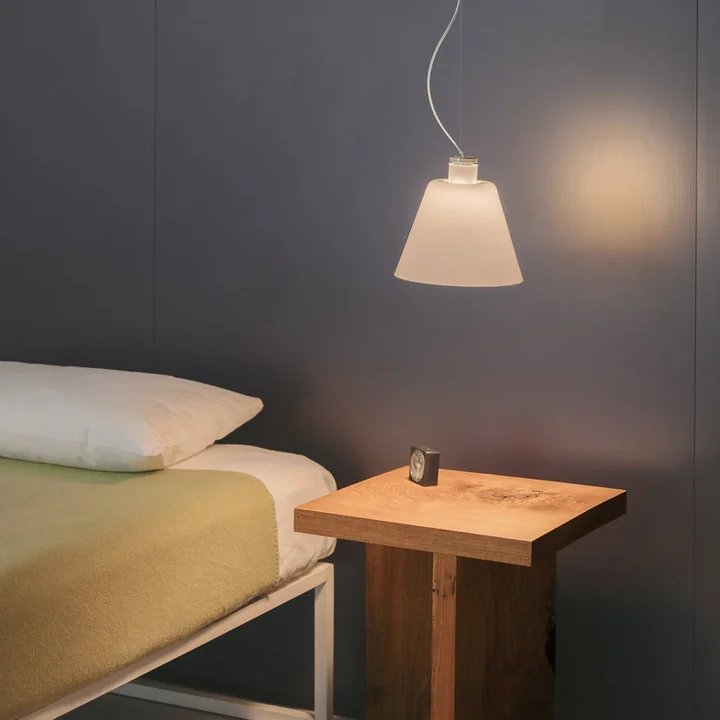 The w202 Halo LED pendant light S2 from Wästberg above the wooden bedside table next to the bed