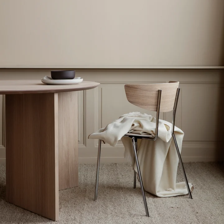 The Herman Chair from Ferm Living with a light ceiling next to an oak dining table