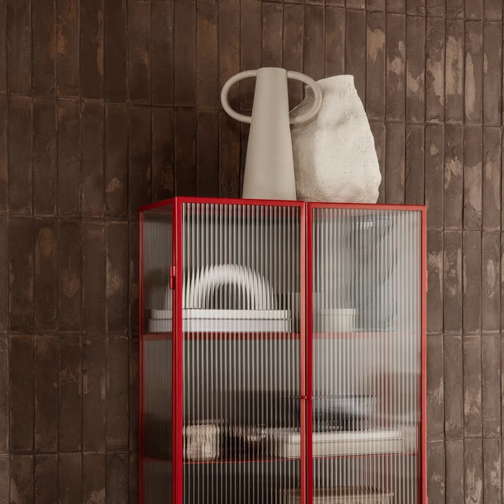 The Vulca Vase by Ferm Living next to the Anse vase on a bookshelf with glass walls