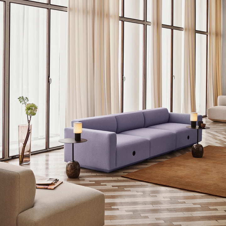 The Manhattan battery-powered table lamps from & Tradition on artistic side tables next to a lilac-coloured couch