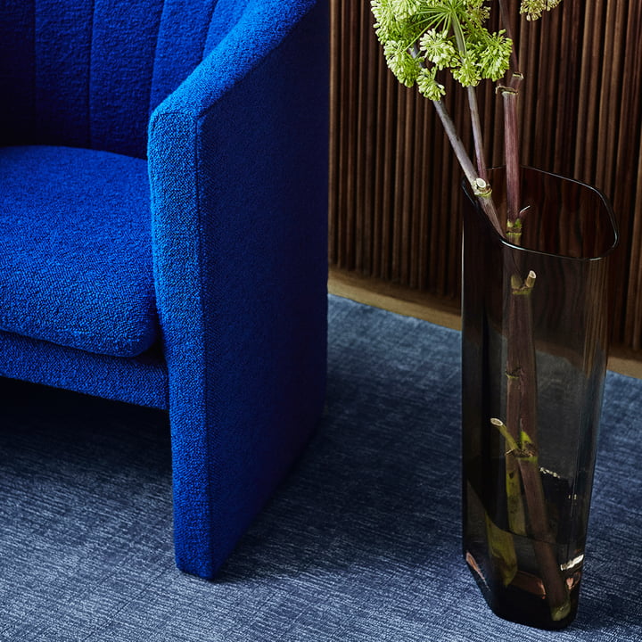 The large Collect vase from & tradition in smoke next to a blue armchair