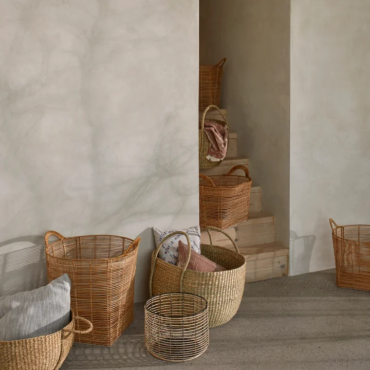 The various Safi rattan baskets from Broste Copenhagen on a stone staircase