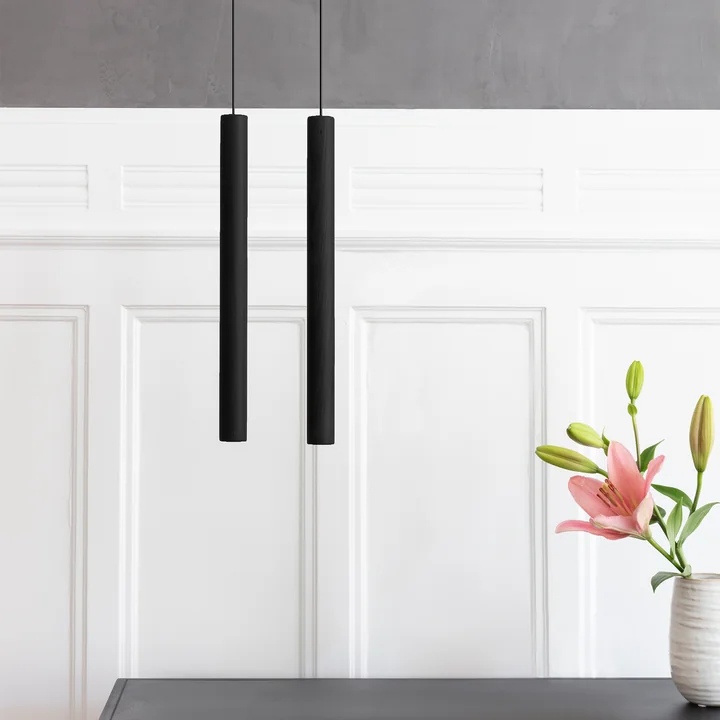The Chimes Pendant lamp LED from Umage in black against a white wooden wall
