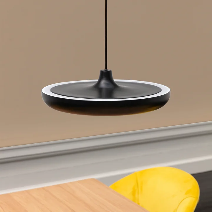 The Cassini LED pendant lamp Medium from Umage in black over a wooden table with yellow chair