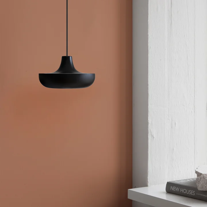 The Cassini LED pendant lamp Mini from Umage in black against a reddish brown wall