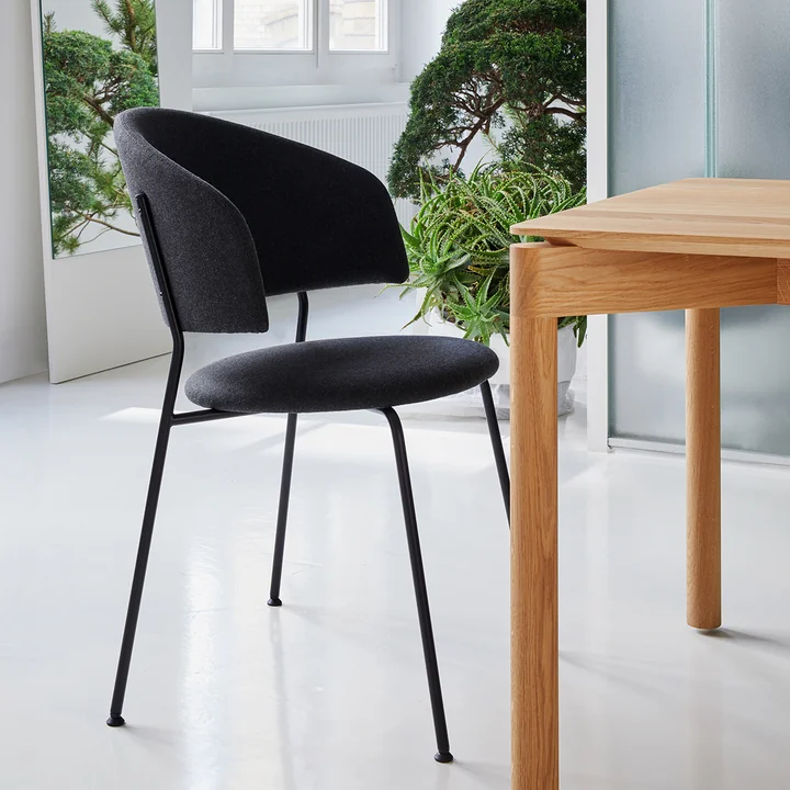 The black Wagner Dining Chair from OUT Objekte unserer Tage at a wooden dining table