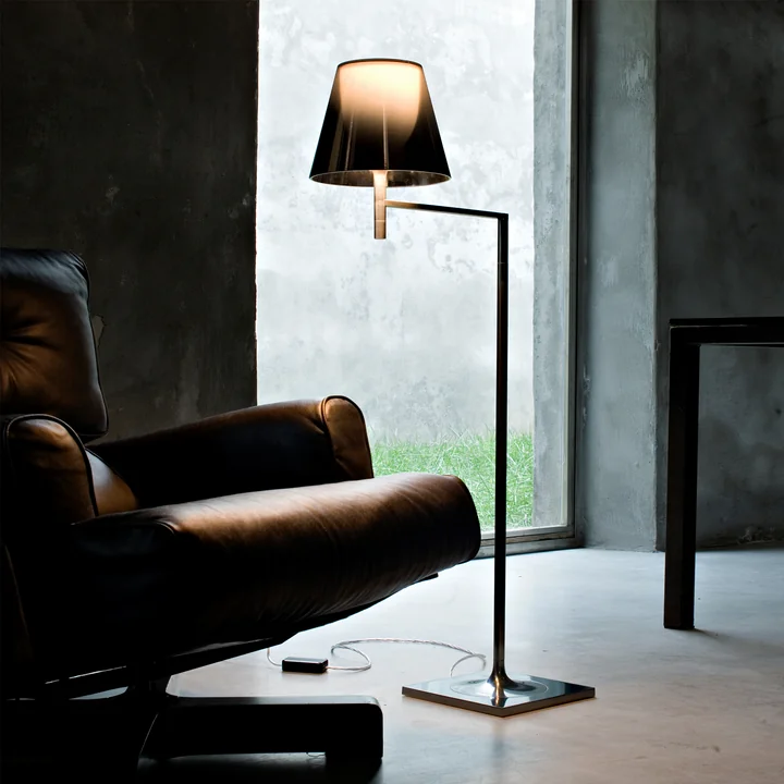 The K Tribe F1 floor lamp from Flos with fumée shade next to a black armchair