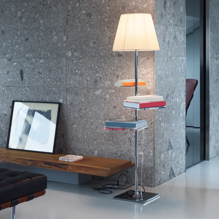 The Bibliotheque Nationale floor lamp from Flos with books and magazines in front of a grey stone wall