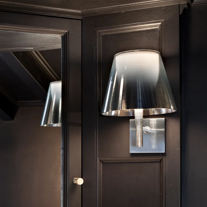 The K Tribe wall lamp from Flos in fumée on a brown wooden wall